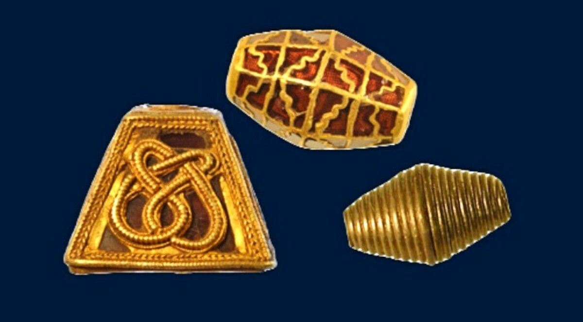 Tzw. piramida (ozdoba pochwy miecza) wykonana ze złota i granatów oraz dwa złote paciorki z Randlesham, Wielka Brytania. Źródło: <a href='https://heritage.suffolk.gov.uk/results-from-rendlesham' rel='noopener'>Suffolk Heritage Explorer</a>.