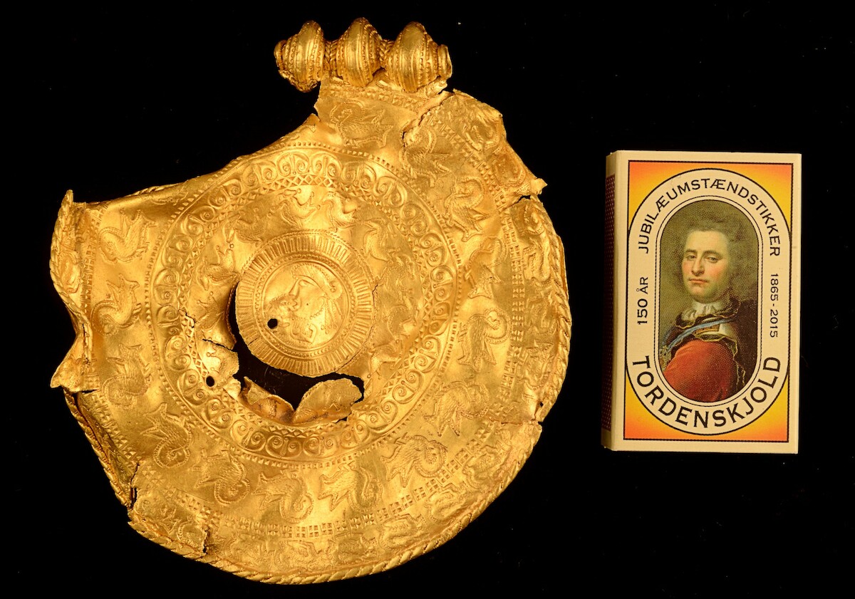Jeden z złotych brakteatów ze skarbu z Vindelev (VI w.), Dania. Źródło: <a href='https://www.vejlemuseerne.dk/viden-og-forskning/artikler/odins-mand-i-vindelev/' rel='noopener'>Vejlemuseerne</a>.