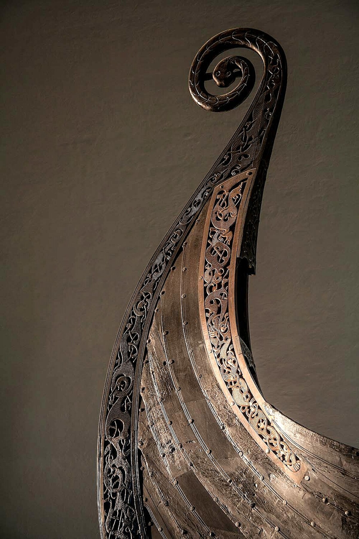Bogato zdobiony dziób słynnego statku z Osebergu. Źródło: <a href='https://www.historiskmuseum.no/english/exhibitions/midgardr/image-carousel/2-stavn-oseberg-marten-teigen-1000px.jpg'>Historisk museum</a>.
