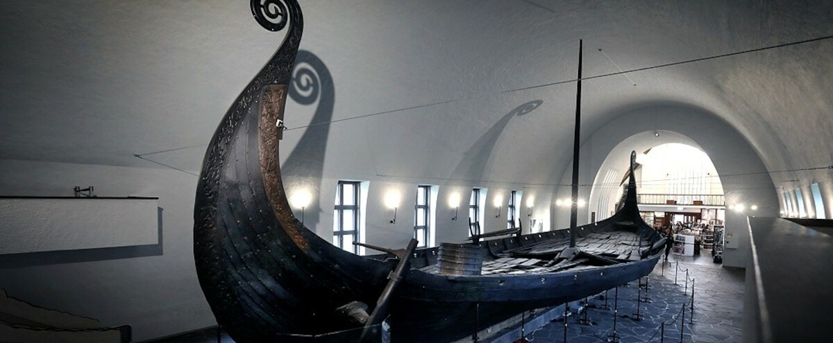 Łódź  Osebergu w Muzeum Statków Wikińskich (przyszłe Muzeum Epoki Wikingów) na półwyspie Bygdøy w Oslo. Źródło: <a href='https://www.vikingtidsmuseet.no/samlingene/oseberg/bilder/osebergskipet-tom-kolstad-970.jpg'>Vikingtidsmuseet </a>.