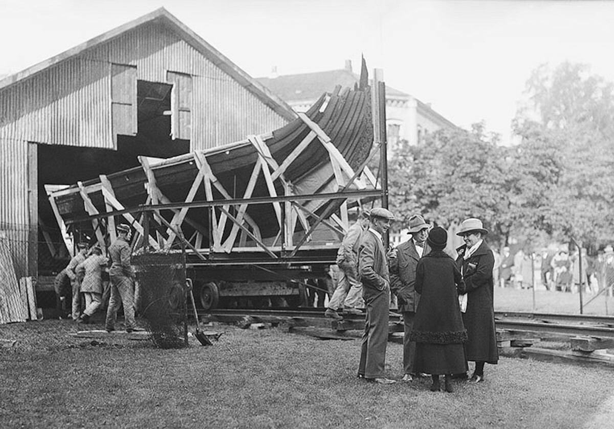 Transport łodzi z Osebergu z Ogrodu Uniwersyteckiego w Oslo do Muzeum Łodzi Wikińskich na Półwyspie Bygdøy w 1926 r. Źródło: <a href='https://www.vikingtidsmuseet.no/english/photo-bank/image-series-relocating-the-oseberg-ship-in-1926/'>Vikingtidsmuseet</a>.